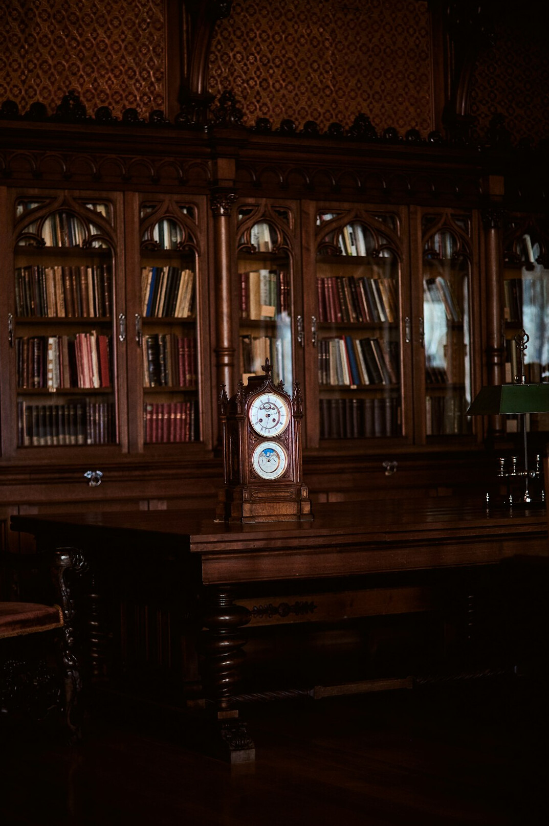 Old grand library with tall wooden shelves and warm light