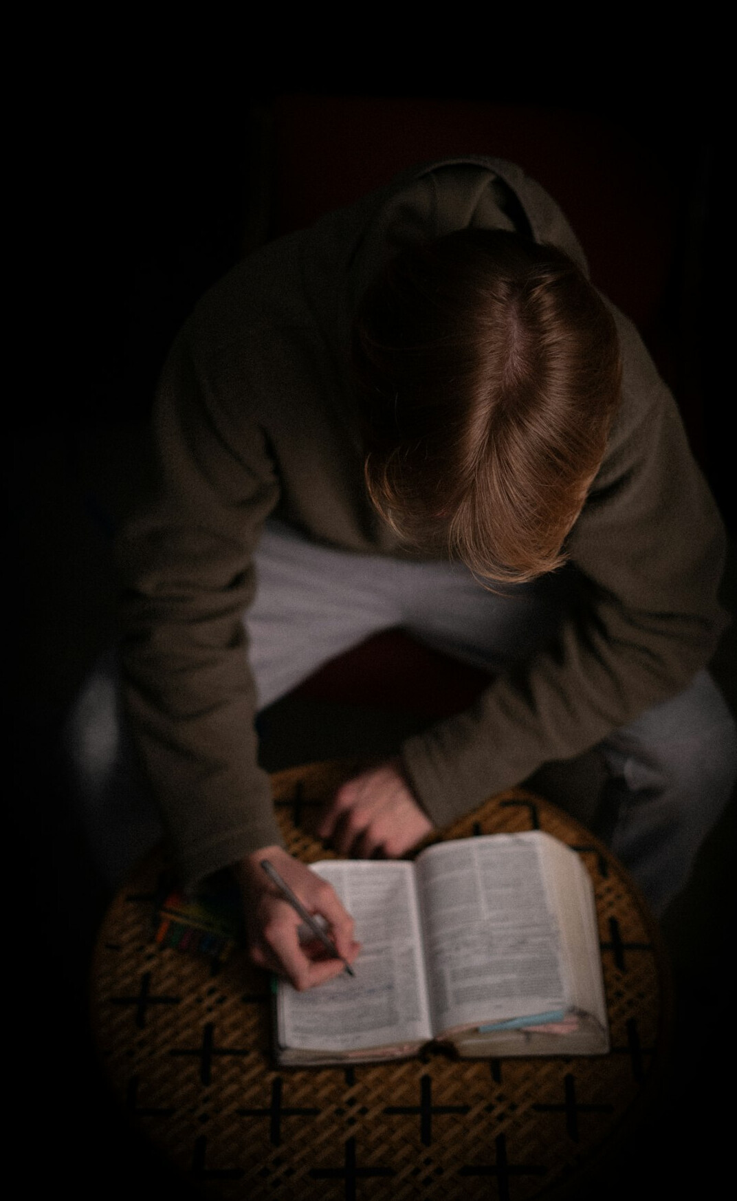 Person writing in a notebook at a desk